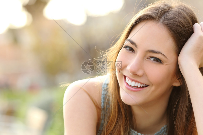 女人在公园里微笑得完美满的笑容和白牙看着摄像机