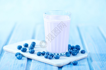 玻璃和桌子上的蓝莓酸奶图片