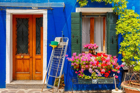 意大利威尼斯著名的布拉诺岛近身装饰着花朵窗户和百叶的丰富多彩房屋图片