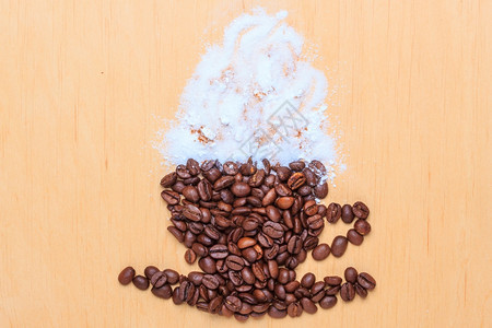 卡布奇诺时间烤咖啡豆以木质表面背景上白霜的杯子和碟形式包装成烤咖啡豆图片