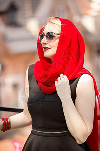 穿着红围巾和太阳眼镜的优雅金发女子近视肖像图片