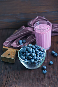 木制桌上有蓝莓的酸奶图片