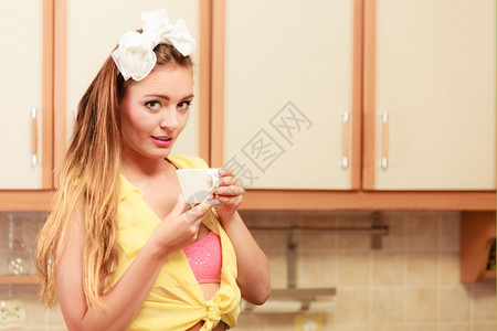 漂亮的女孩带发弓在家里喝茶或咖啡背景图片
