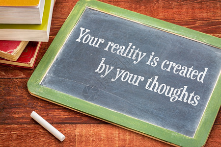 你的现实是由思想创造在黑板上充满灵感的短语白粉和一堆书与生锈的木板对立图片