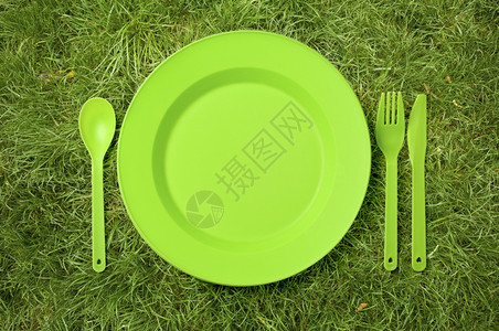 户外野餐绿色草地上的可支配餐具背景