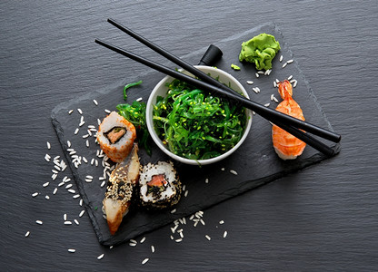 寿司和海草沙拉放在桌子上图片