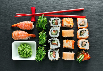 一套寿司配有芥末和筷子在板上图片