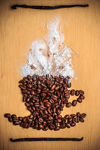 卡布奇诺时间烤咖啡豆以杯形式放置木质面底有白霜香草豆图片
