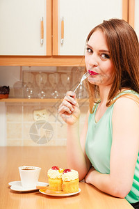 喝咖啡的女人吃着美味食的甜蛋糕和橙色图片