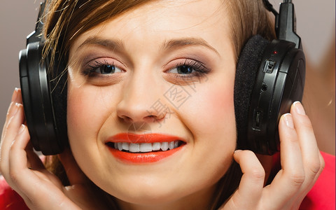 技术音乐和幸福概念在耳机中听音乐的笑少女图片
