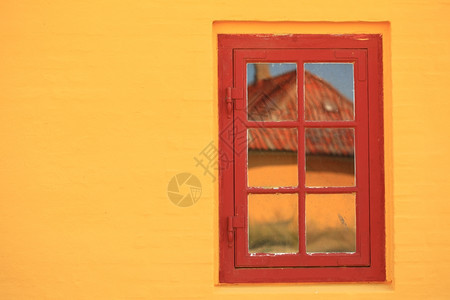 橙色墙壁背景房屋外结构细节的红色窗口扫描图片