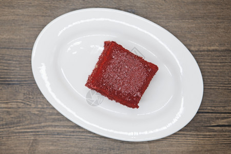 红天鹅绒新鲜美味饮食蛋糕在Dukan迪肯餐饮店在木本底的瓷板上图片
