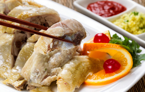 切片鸡的近前视线有选择地关注筷子中的单片配有酱和加醋图片