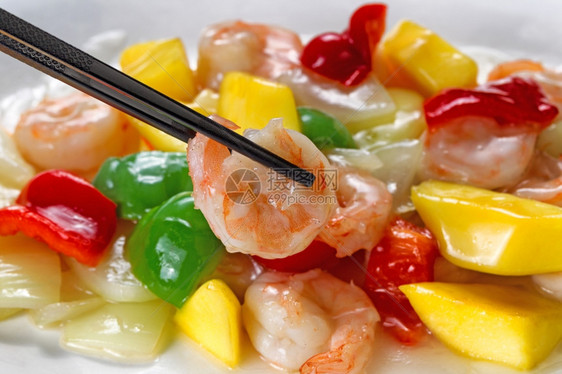 近距离看一头苏食虾有选择地关注筷子中的单片背景有新鲜的胡椒涂在洋葱上图片