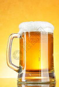 黄背景上浮青的啤酒杯图片