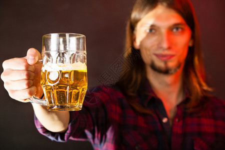 帅的年轻人拿着一杯啤酒图片