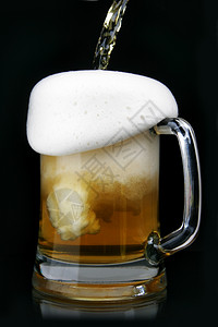 将啤酒倒在玻璃杯子里图片