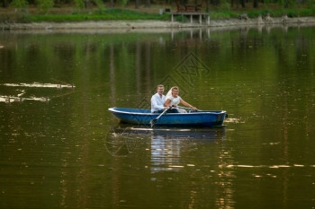 美丽的年轻新娘和郎在湖上乘船图片
