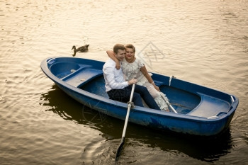 快乐的新娘和郎拥抱在划船上图片