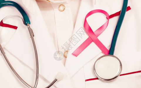 妇女为健康而斗争乳腺癌肿瘤概念粉色丝带和蓝听诊器图片