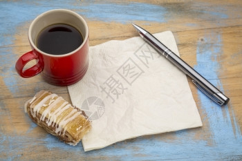 白餐巾纸上面有笔加咖啡和饼干图片