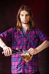酒鬼喝的放松派对概念酒鬼喝的瓶装斯坦因年轻的男酒保喝啤倒在玻璃上图片