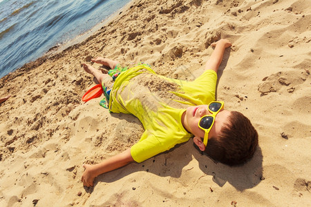 小男孩在海边沙滩上玩得开心小孩子在夏日新鲜空气中度过时光图片