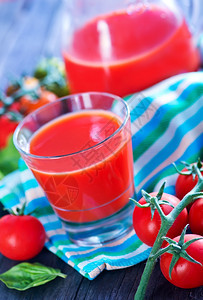 番茄汁在玻璃和桌上图片