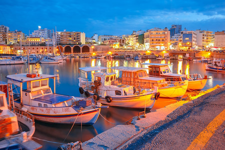 希腊克里特的拉翁旧港在清晨的蓝色时刻有渔船和码头在前景上模糊了运动图片
