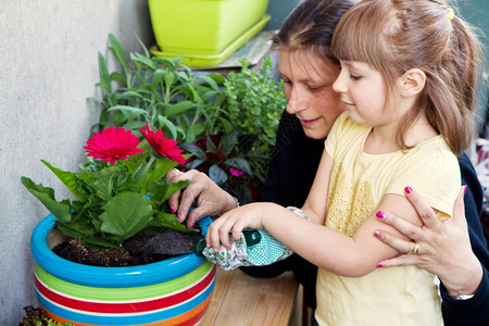 年轻女孩微笑着给植物浇水图片