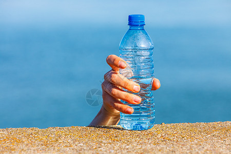 男手取走户外的塑料瓶水男手取走海边的塑料瓶水图片