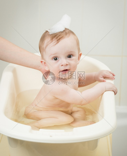 可爱的婴儿男孩肖像头上有泡沫洗澡时间图片