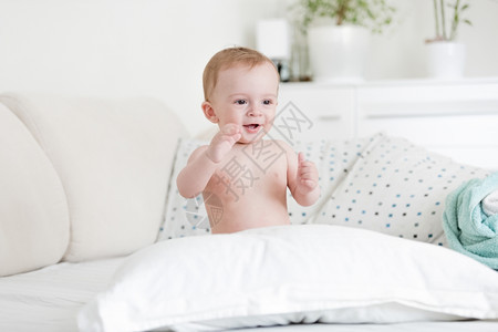 喜悦的小男孩肖像他们用枕头在床上玩耍图片