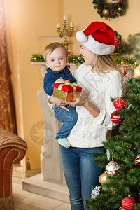 圣诞时在树旁边的客厅里给小儿子送礼物圣诞树旁边的客厅里图片