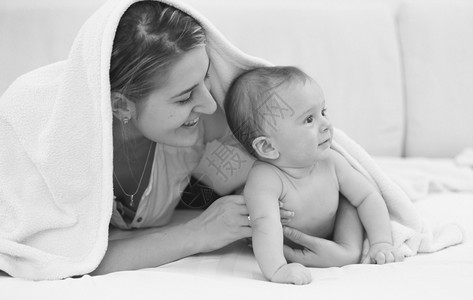 黄河母亲像带着6个月的儿子躺在床上年轻快乐母亲黑白像背景