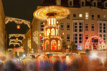 德国萨克森累斯顿市圣诞街夜间配有旋转木马装饰和照亮圣诞街图片