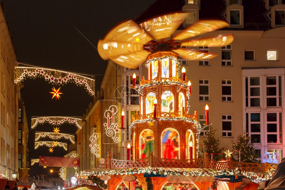 德国萨克森累斯顿市圣诞街夜间配有旋转木马装饰和照亮圣诞街图片