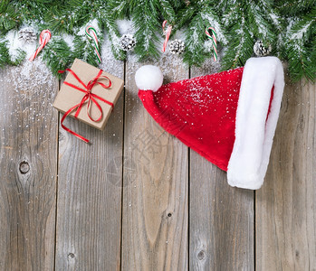 圣诞假日木背景包括壁枝雪圣诞帽和构成上界的礼品盒图片
