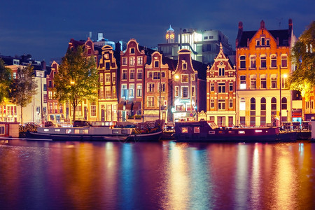 荷兰阿姆斯特丹运河典型的荷兰码头房屋和内船夜间有多色反射图片