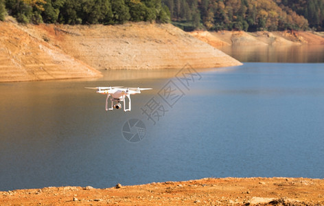 无人驾驶飞行器在湖面上空飞行图片