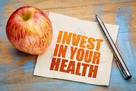 投资于你的健康鼓舞人心的字摘要用新鲜苹果在餐巾纸上图片