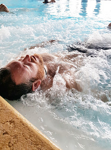 男人在浴缸旁的温泉里放松图片