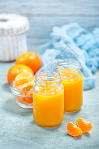 在玻璃库和桌上的橘子汁图片