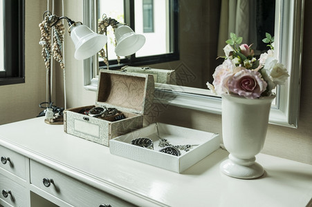 美容和化妆概念镜像光珠宝和桌上的化妆盒图片