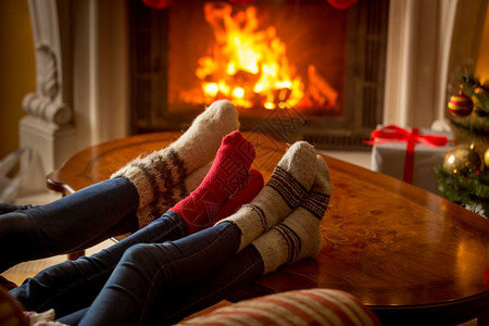 男女双脚穿羊毛袜在燃烧的壁炉上升温图片