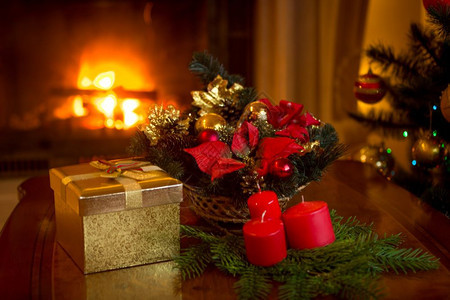 美丽的圣诞树和一堆礼物在燃烧的壁炉前图片