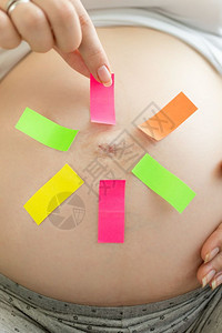 孕妇在多彩备忘录标签上做出选择的概念形象图片