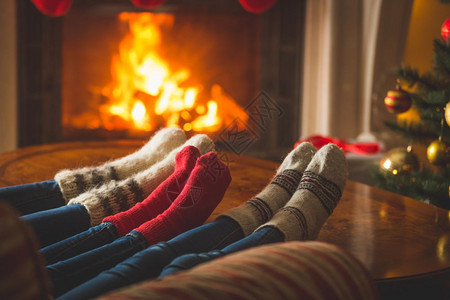 穿羊毛袜的男女双脚在小屋壁炉里变暖图片