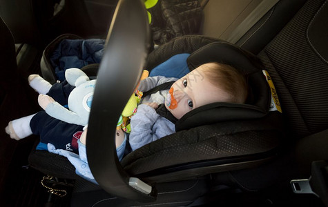 坐在汽车婴儿安全座椅上的男孩图片