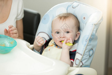 9个月的婴儿男孩勺子坐在高椅上图片